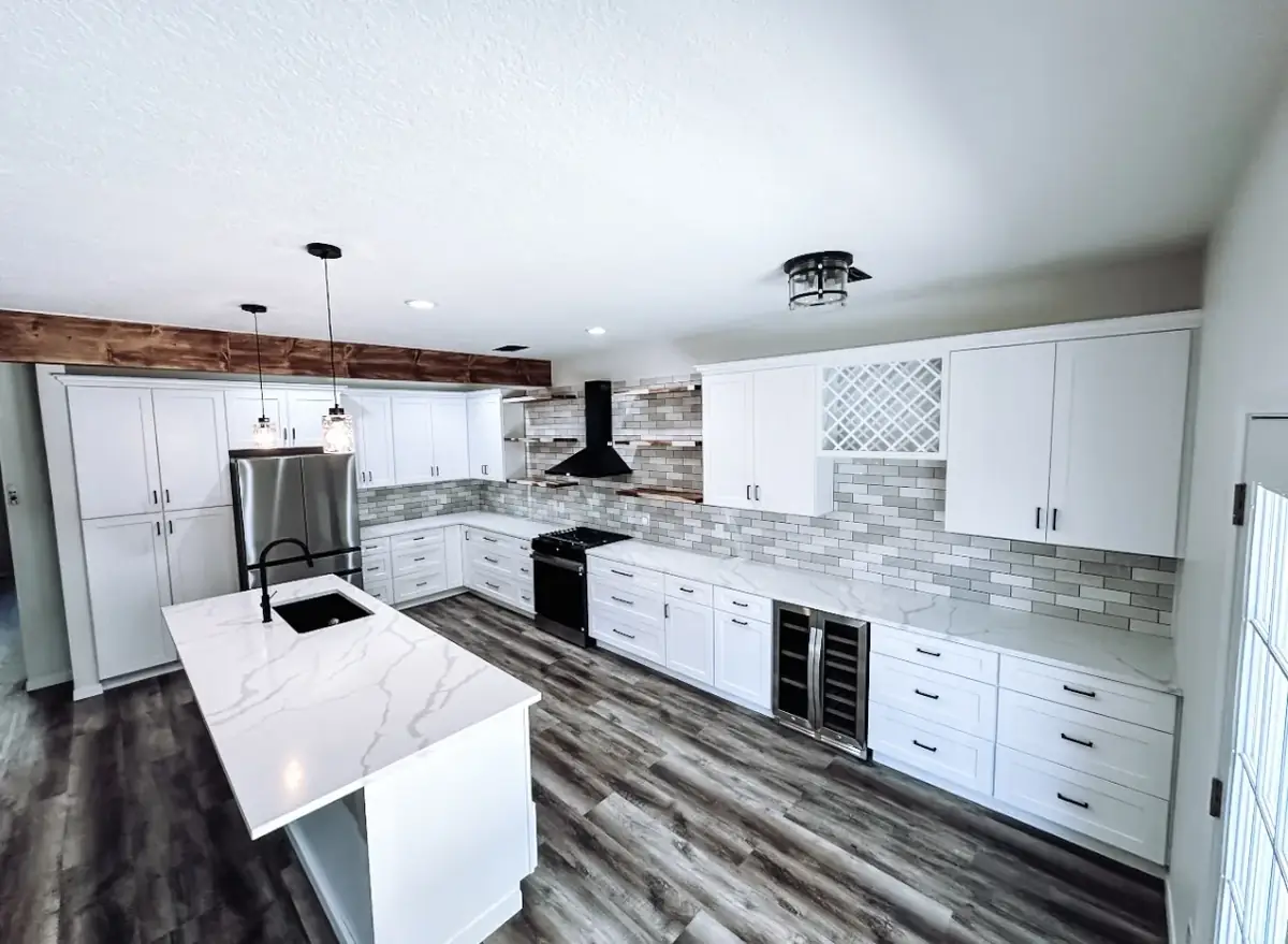 Bright open-concept remodeled kitchen with white quartz island, black fixtures, and French doors to the backyard